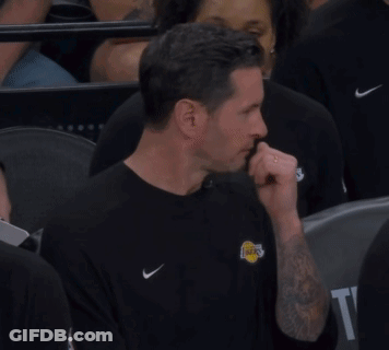 A Man Wearing A Lakers Shirt Is Sitting In A Crowd Of People GIF