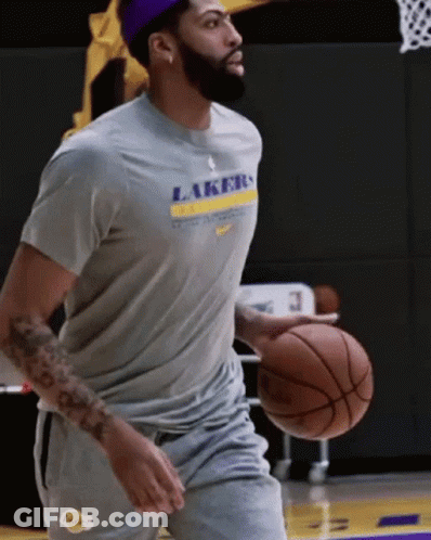 A Man Wearing A Lakers T-Shirt Holds A Basketball GIF