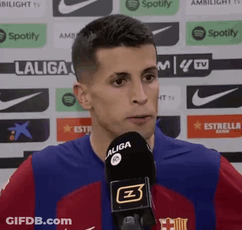 A Man Wearing A Laliga Jersey Is Talking Into A Microphone . GIF
