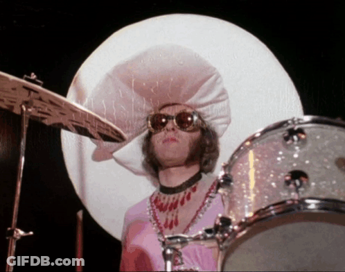 A Man Wearing A Large White Hat And Sunglasses Playing Drums GIF