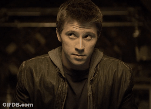 A Man Wearing A Leather Jacket And A Hoodie Looks To His Left GIF