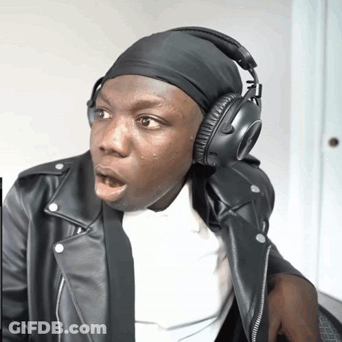 A Man Wearing A Leather Jacket And Headphones Looks Surprised GIF
