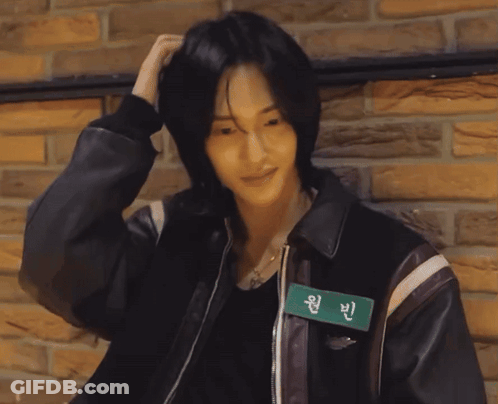 A Man Wearing A Leather Jacket Has A Name Tag That Says Wan Bin On It GIF