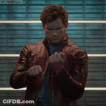 A Man Wearing A Leather Jacket Is Standing In Front Of A Wall . GIF