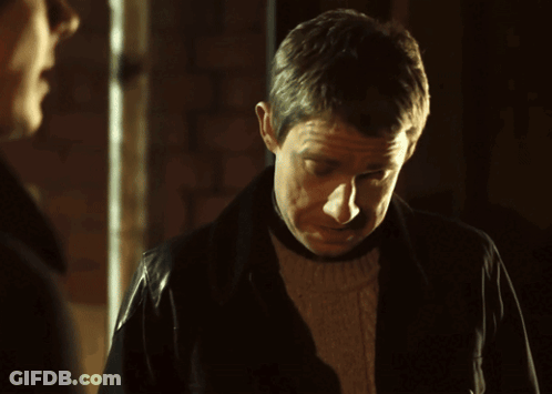 A Man Wearing A Leather Jacket Looks Down At Something GIF