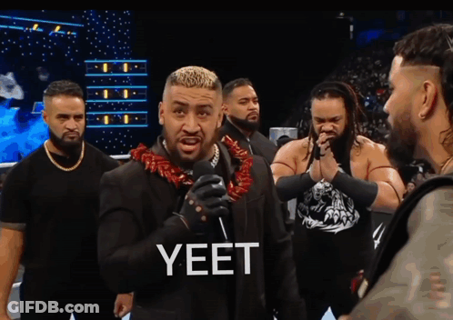 A Man Wearing A Lei Stands In Front Of A Microphone GIF