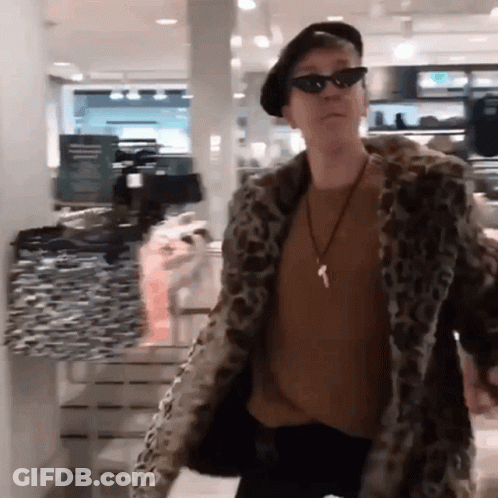 A Man Wearing A Leopard Print Coat And Sunglasses GIF