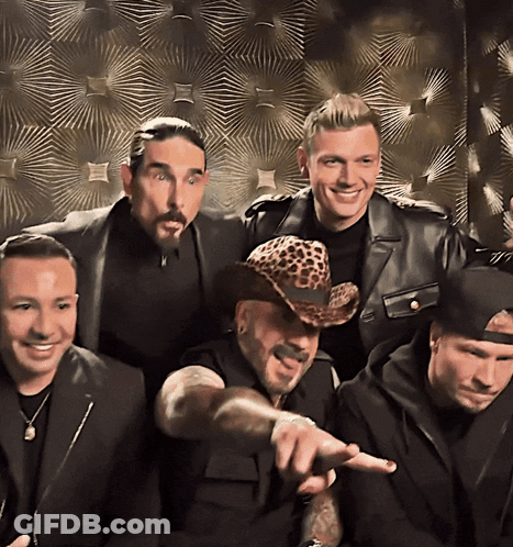 A Man Wearing A Leopard Print Hat Points At Something GIF