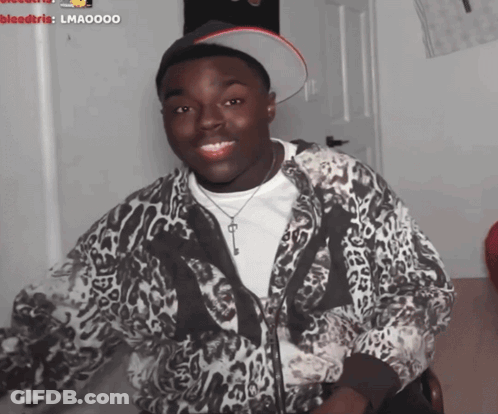 A Man Wearing A Leopard Print Jacket And A Hat With A Key On It GIF