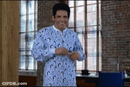 A Man Wearing A Leopard Print Pajama Top Is Standing In Front Of A Window GIF