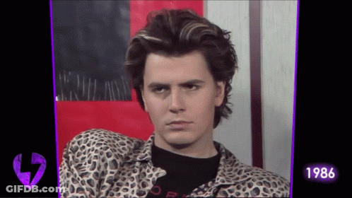 A Man Wearing A Leopard Print Shirt And A Black Shirt With The Year 1986 On It GIF