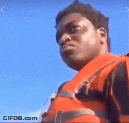 A Man Wearing A Life Jacket Is Standing On A Boat . GIF