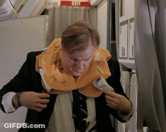 A Man Wearing A Life Vest On An Airplane With Movieclips.com Written Below Him GIF
