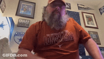 A Man Wearing A Longhorns Shirt Is Sitting In A Room GIF
