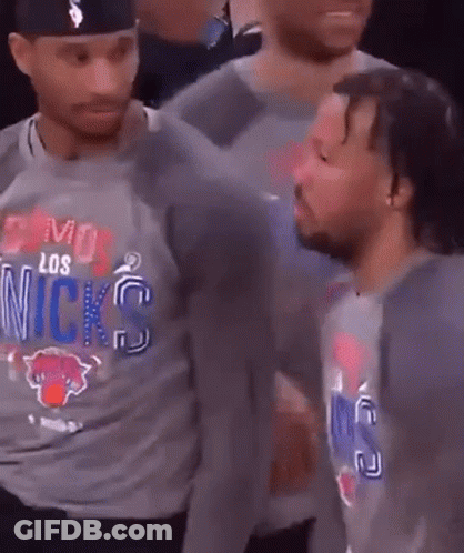 A Man Wearing A Los Angeles Knicks Shirt Is Talking To Another Man . GIF