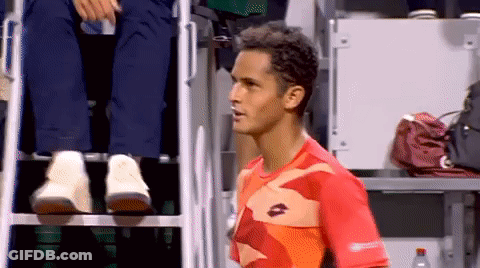 A Man Wearing A Lotto Shirt Stands In Front Of A Referee 'S Chair GIF