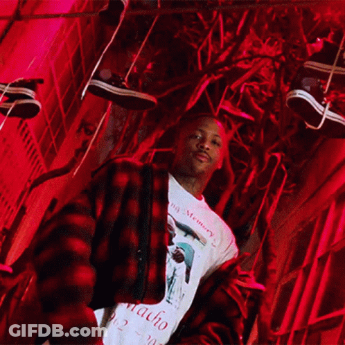 A Man Wearing A Macho Shirt Stands In Front Of A Red Light GIF