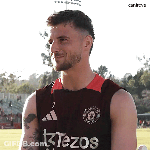 A Man Wearing A Manchester United Jersey Looks At The Camera GIF