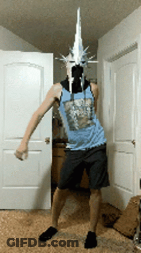 A Man Wearing A Mask And A Blue Tank Top Is Standing In Front Of A Door GIF
