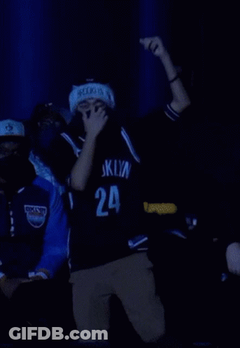 A Man Wearing A Mask And A Brooklyn Jersey Is Dancing GIF