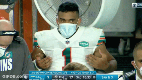 A Man Wearing A Mask And A Dolphins Jersey GIF