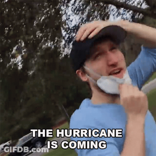 A Man Wearing A Mask And A Hat Says The Hurricane Is Coming GIF