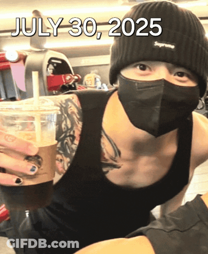 A Man Wearing A Mask And A Supreme Beanie Is Holding A Cup Of Coffee On July 30 2025 GIF