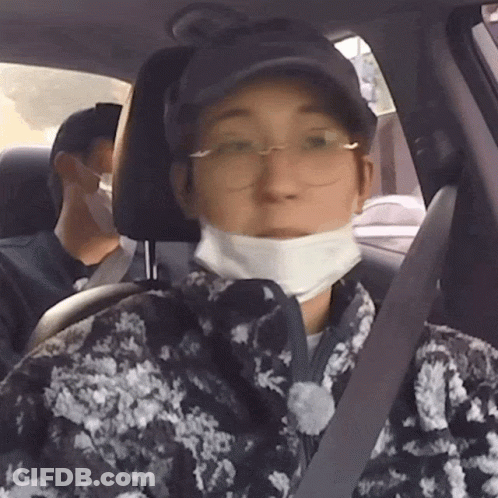 A Man Wearing A Mask And Glasses Is Sitting In A Car GIF