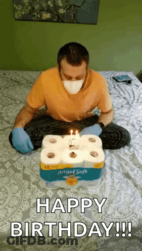 A Man Wearing A Mask And Gloves Is Celebrating His Birthday With Toilet Paper Rolls . GIF