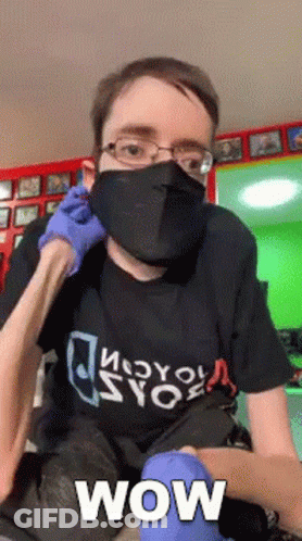 A Man Wearing A Mask And Gloves With The Word Wow Written On It GIF