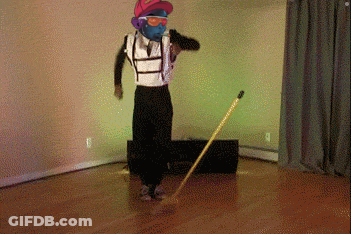 A Man Wearing A Mask And Sunglasses Is Dancing With A Broom GIF