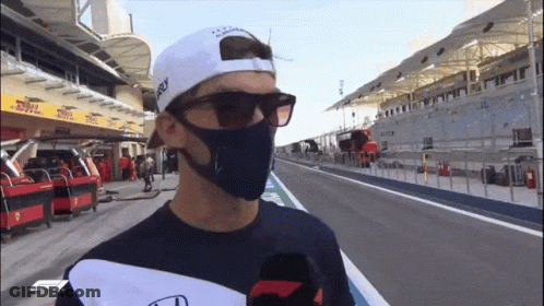 A Man Wearing A Mask And Sunglasses Is Standing On A Track GIF