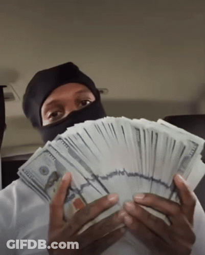 A Man Wearing A Mask Holds A Stack Of 100 Dollar Bills In Front Of His Face GIF
