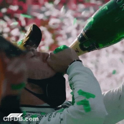 A Man Wearing A Mask Is Drinking From A Bottle Of Champagne GIF