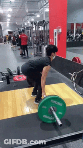 A Man Wearing A Mask Is Lifting A Green Barbell With The Word Strength On It GIF