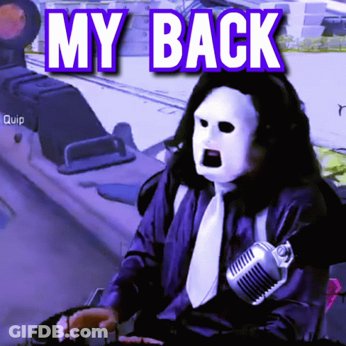 A Man Wearing A Mask Is Sitting In Front Of A Microphone With The Words My Back Above Him GIF