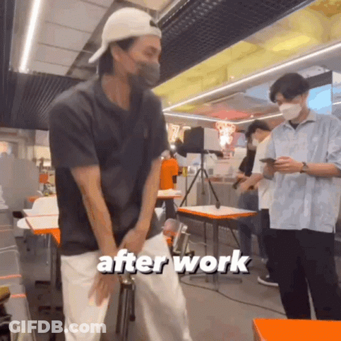 A Man Wearing A Mask Is Standing In A Restaurant With The Words After Work Written On The Bottom Of The Image . GIF