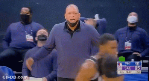 A Man Wearing A Mask Is Standing In Front Of A Basketball Player During A Basketball Game . GIF