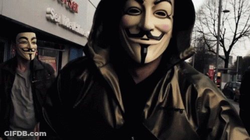 A Man Wearing A Mask Is Standing In Front Of A Building That Says Sex Machine GIF