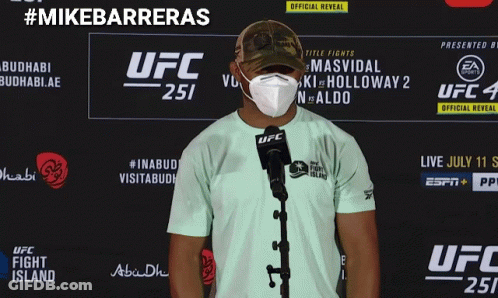 A Man Wearing A Mask Is Standing In Front Of A Ufc Sign GIF