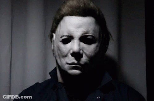 A Man Wearing A Mask Looks At The Camera GIF