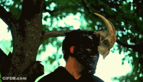 A Man Wearing A Mask With A Horn On His Head GIF