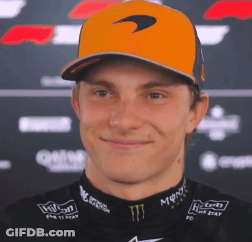 A Man Wearing A Mclaren Hat And A Monster Shirt Smiles GIF