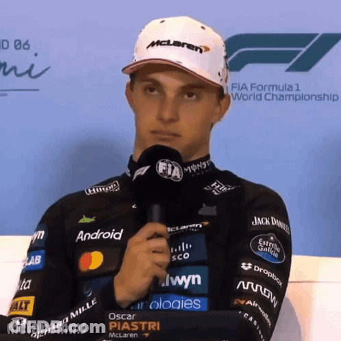 A Man Wearing A Mclaren Hat Holds A Microphone GIF