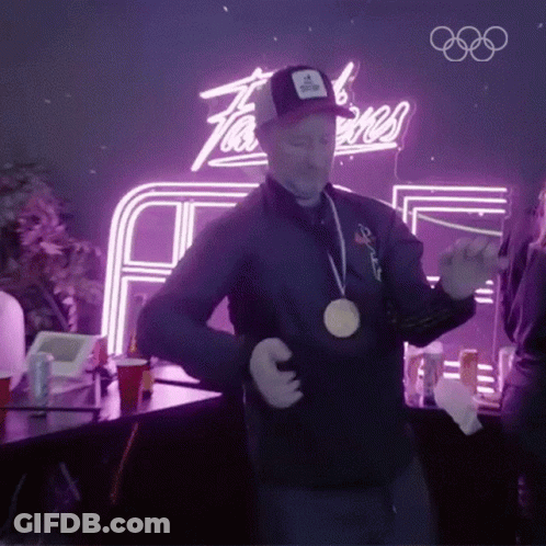 A Man Wearing A Medal Around His Neck Is Dancing GIF