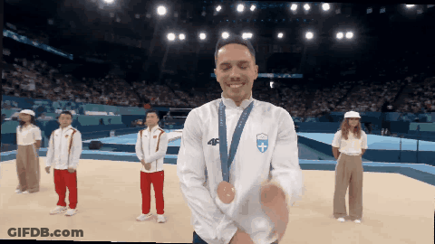A Man Wearing A Medal Around His Neck With The Number 46 On It GIF