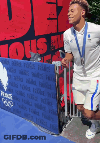 A Man Wearing A Medal Is Standing In Front Of A Sign That Says France GIF
