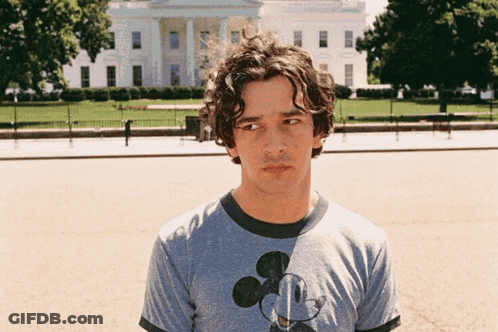 A Man Wearing A Mickey Mouse T-Shirt Stands In Front Of The White House GIF