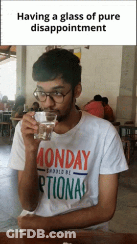 A Man Wearing A Monday Shirt Drinks From A Glass Of Water GIF