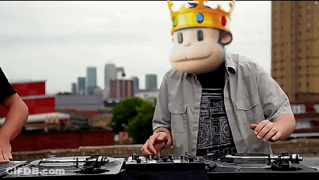 A Man Wearing A Monkey Mask And A Crown Plays Music GIF
